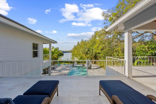 view of patio / terrace featuring a water view and a fenced in pool