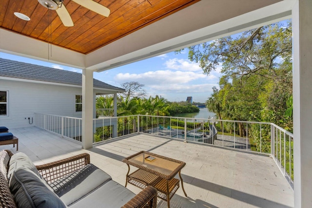 view of patio / terrace with outdoor lounge area, a water view, ceiling fan, and a balcony