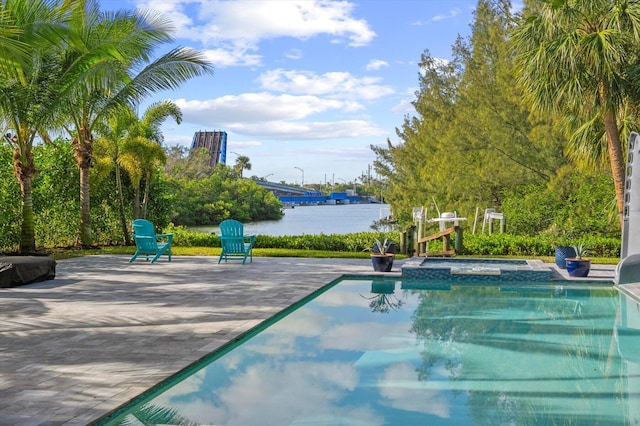 view of pool featuring a water view, a patio, and an in ground hot tub