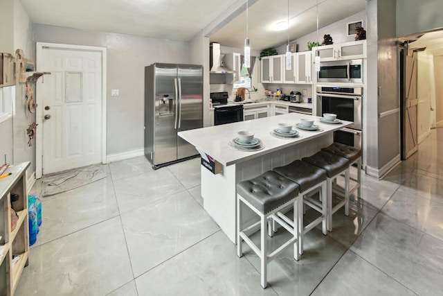 kitchen featuring appliances with stainless steel finishes, sink, white cabinetry, and pendant lighting