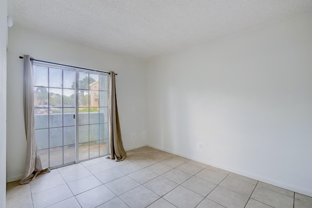 unfurnished room with light tile patterned floors and a textured ceiling