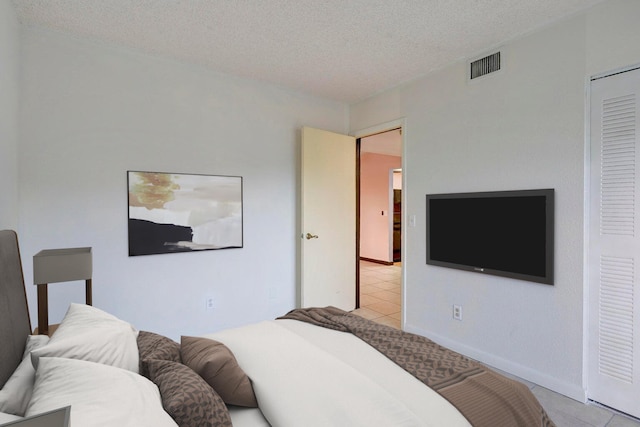 tiled empty room featuring a textured ceiling