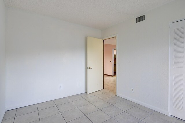 tiled spare room with a textured ceiling