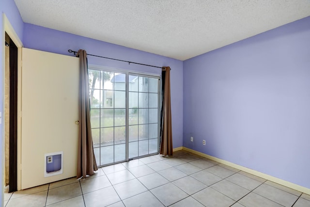 empty room featuring light tile patterned floors and a textured ceiling