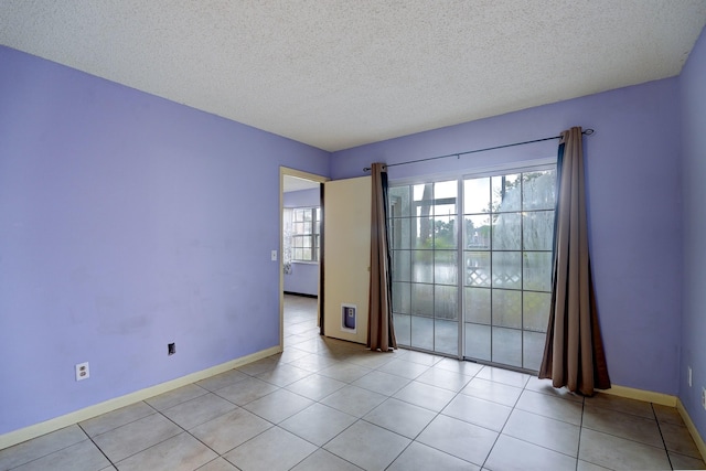 tiled spare room featuring a textured ceiling