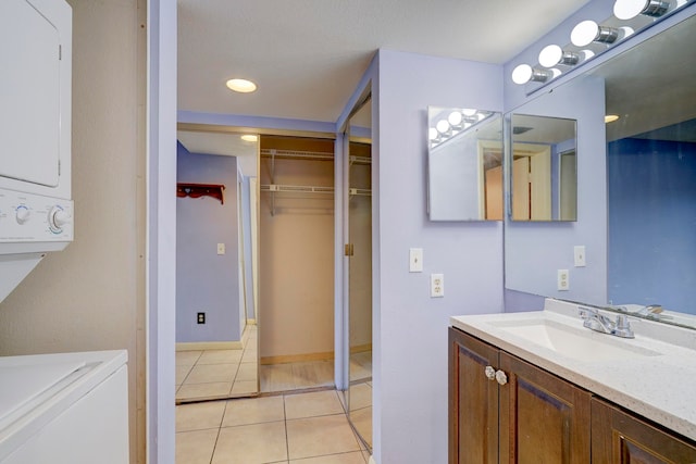 bathroom featuring vanity, tile patterned floors, and stacked washer and clothes dryer