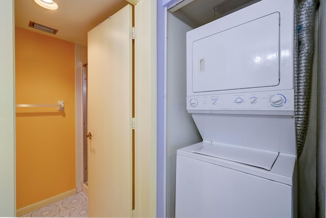 washroom featuring stacked washer and clothes dryer