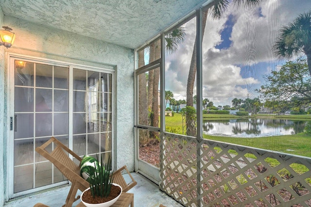 sunroom featuring a water view