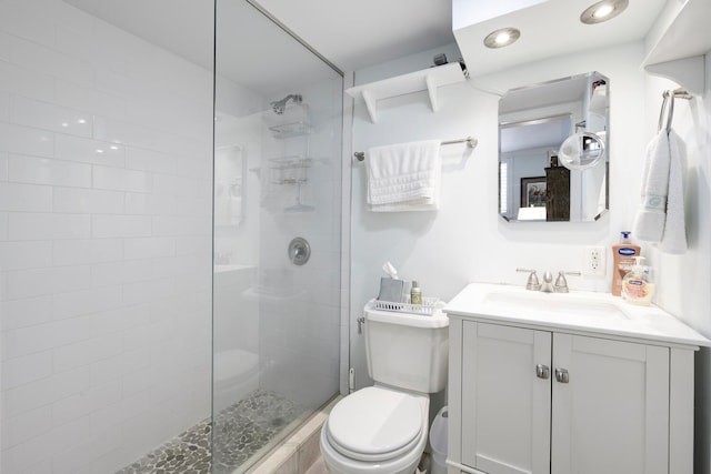 bathroom with toilet, a shower with door, and vanity