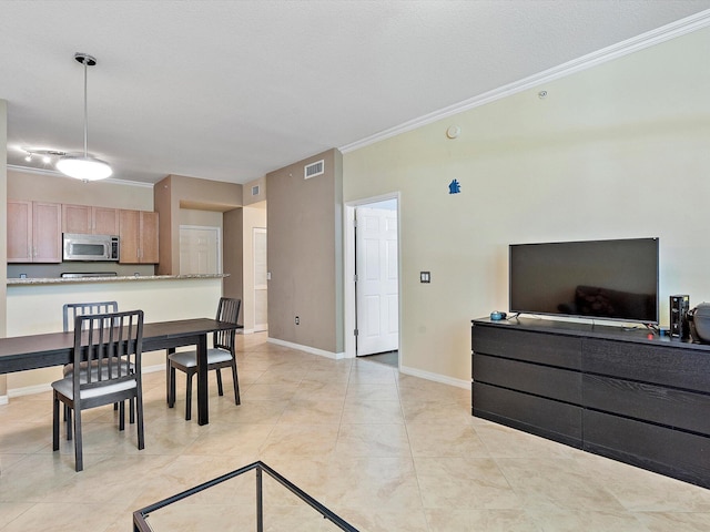 dining room with light tile patterned floors and crown molding