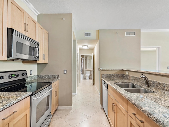 kitchen with light tile patterned floors, stainless steel appliances, crown molding, and sink