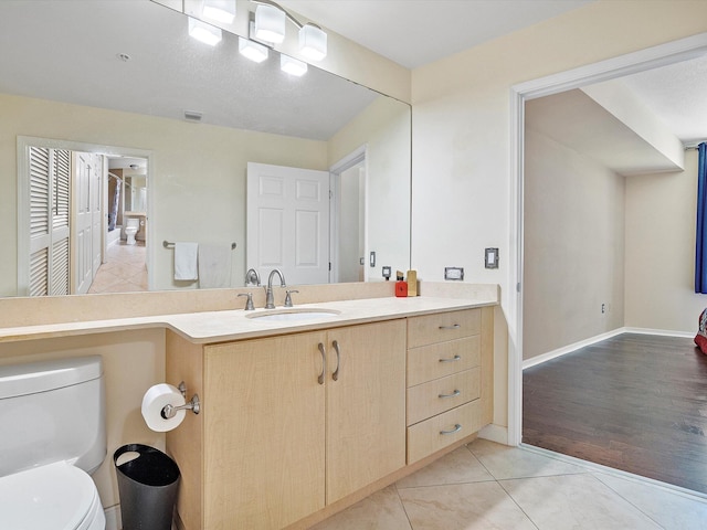 bathroom with tile patterned flooring, toilet, and vanity