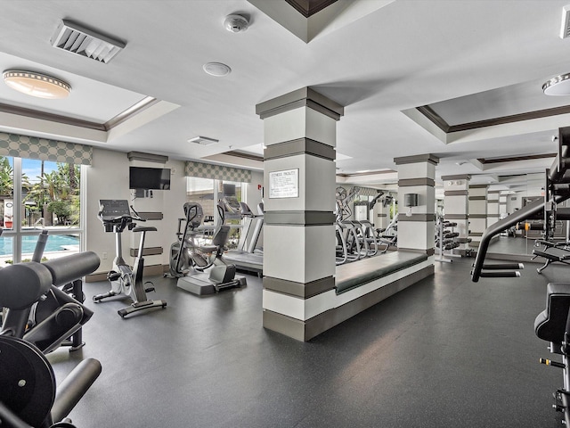 exercise room featuring ornamental molding and a tray ceiling