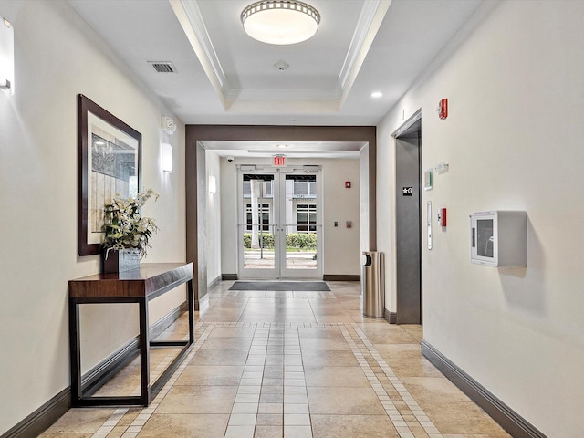 corridor featuring elevator, french doors, a raised ceiling, and light tile patterned floors