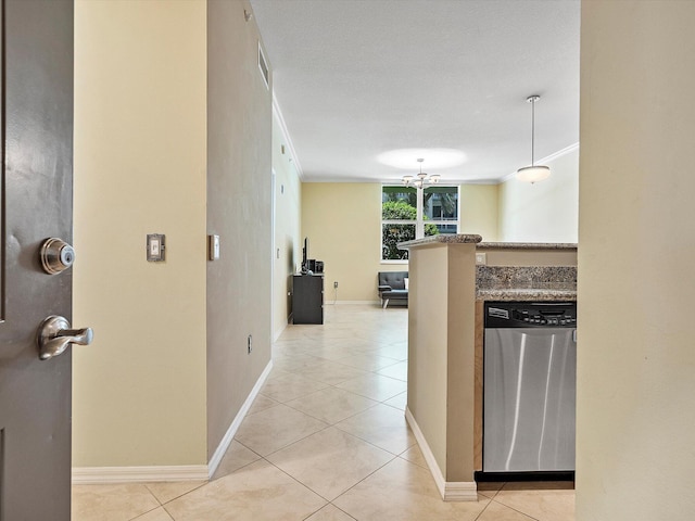 kitchen featuring light tile patterned flooring, a textured ceiling, kitchen peninsula, and stainless steel dishwasher