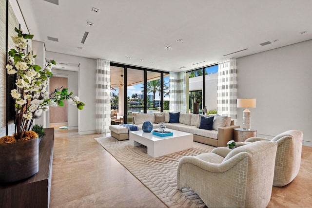 living room with visible vents, baseboards, and floor to ceiling windows