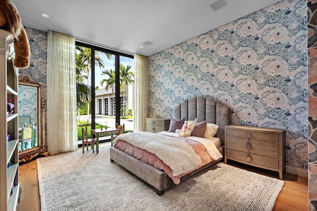 190 NE 5th Ave, Boca Raton, FL 33432 - bedroom with wallpapered walls, access to outside, wood finished floors, and a wall of windows