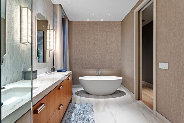 bathroom with vanity and a washtub