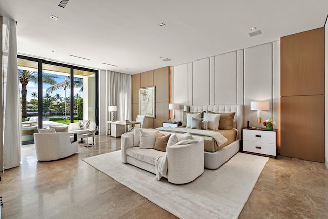 bedroom featuring expansive windows and a decorative wall