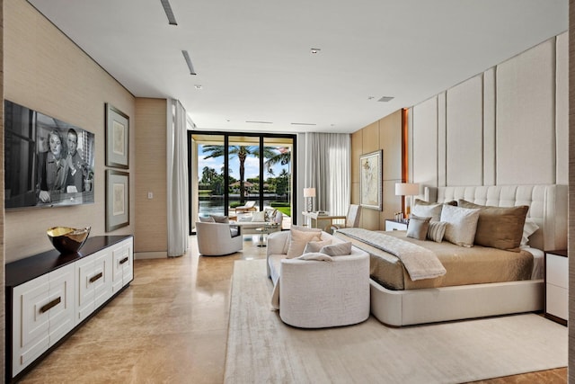 bedroom with access to exterior, finished concrete floors, and floor to ceiling windows