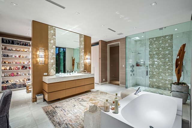 full bathroom featuring vanity, a garden tub, a stall shower, and marble finish floor