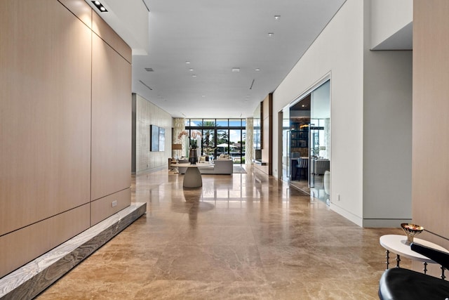 hall with baseboards and floor to ceiling windows