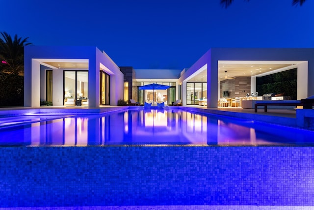 pool at night with a patio area