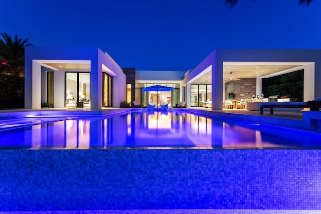 190 NE 5th Ave, Boca Raton, FL 33432 - pool at night featuring a patio, an infinity pool, and a jacuzzi
