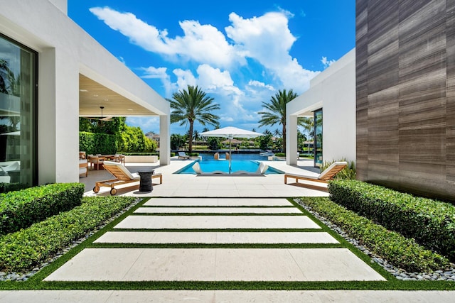 pool with ceiling fan and a patio