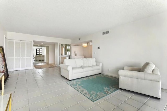 living room with light tile patterned flooring and a textured ceiling