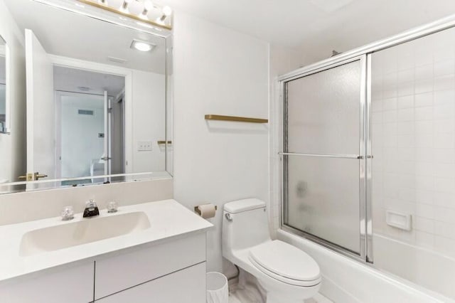 full bathroom with shower / bath combination with glass door, vanity, and toilet