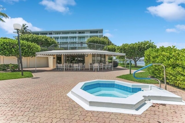 view of pool featuring fence, a patio, and an in ground hot tub