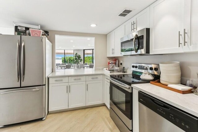 dining space featuring recessed lighting, a water view, light wood-style flooring, and floor to ceiling windows