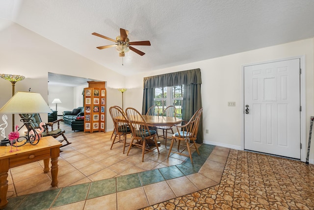 dining room featuring lofted ceiling, ceiling fan, baseboards, and a textured ceiling