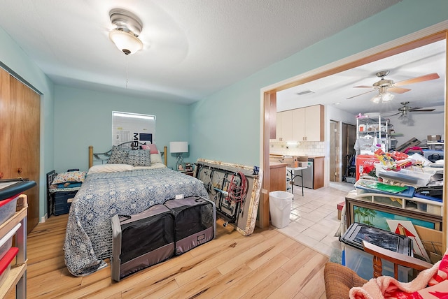 bedroom with ceiling fan, light hardwood / wood-style floors, and ensuite bathroom