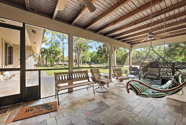 unfurnished sunroom with ceiling fan, beamed ceiling, and wooden ceiling