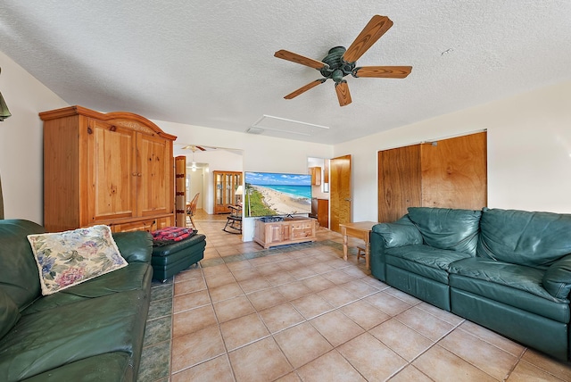 tiled living room with ceiling fan and a textured ceiling