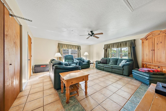 living room with ceiling fan, a textured ceiling, and light tile patterned flooring