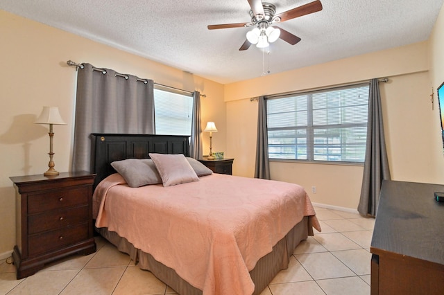 tiled bedroom featuring multiple windows, ceiling fan, and a textured ceiling