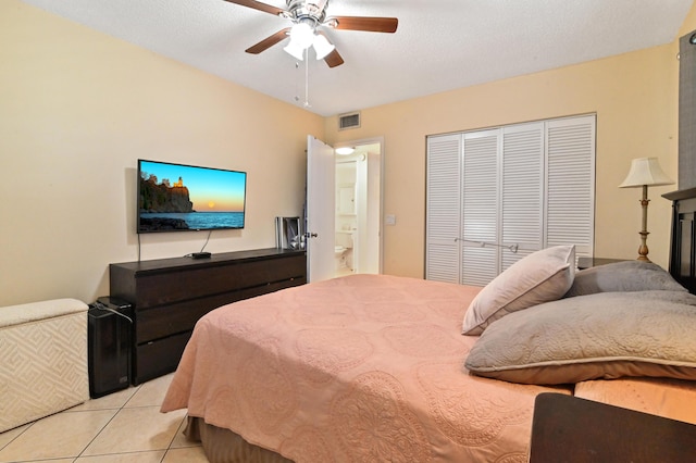 tiled bedroom with a textured ceiling, a closet, and ceiling fan