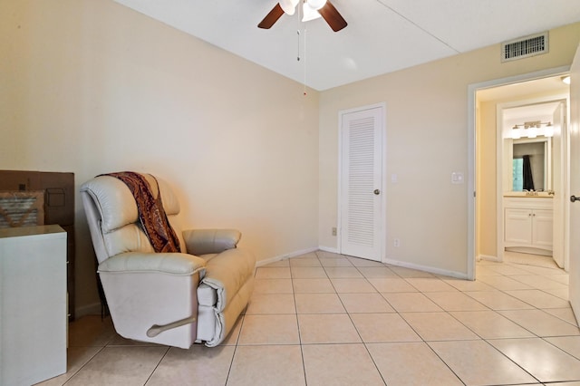 living area with ceiling fan and light tile patterned flooring