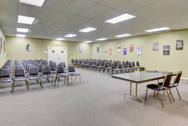 interior space with carpet floors and a drop ceiling