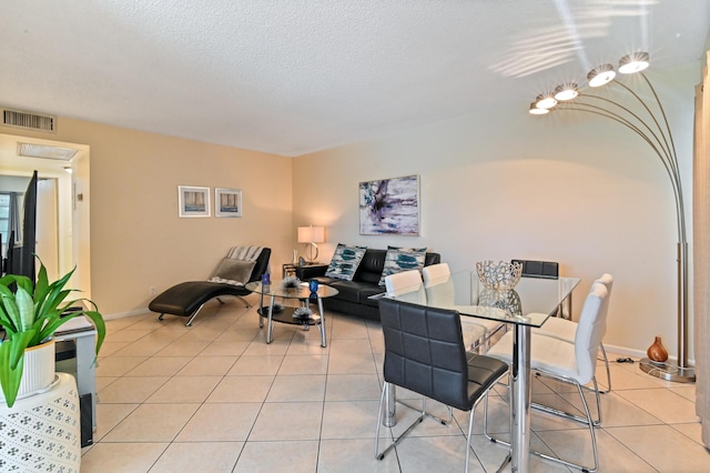 tiled dining space with a textured ceiling