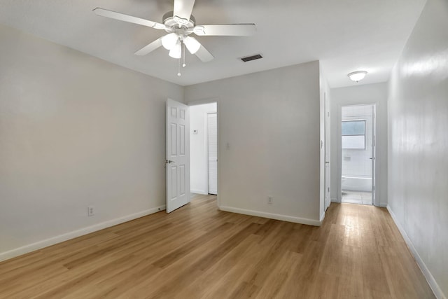 unfurnished bedroom featuring connected bathroom, ceiling fan, and light wood-type flooring