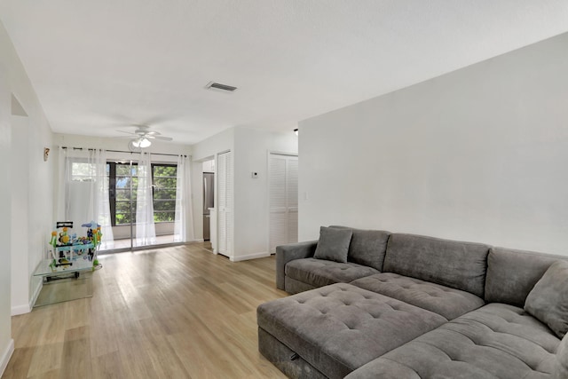 living room featuring ceiling fan and light hardwood / wood-style flooring