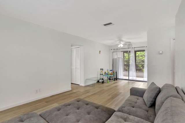 living room featuring ceiling fan and light hardwood / wood-style floors