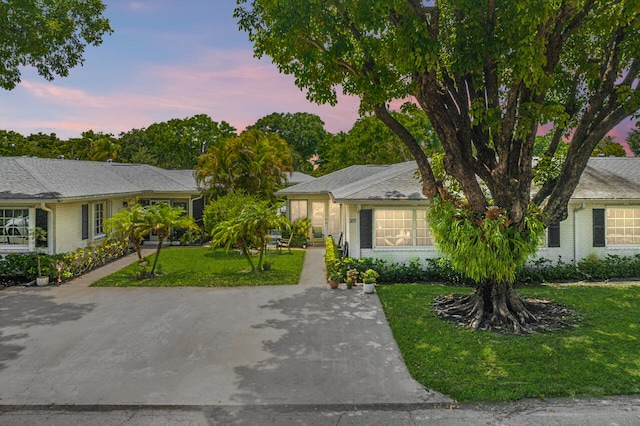 single story home featuring a lawn