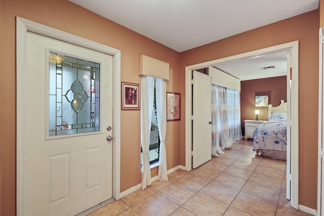 tiled entrance foyer featuring a textured ceiling