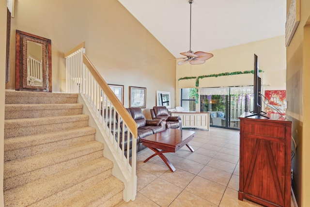 staircase featuring tile patterned floors, ceiling fan, and high vaulted ceiling