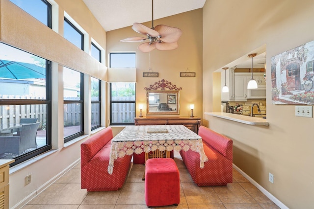 interior space with ceiling fan, high vaulted ceiling, and light tile patterned floors